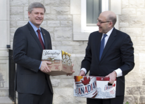 Harper collecting on a cross border beer swap from a hockey bet with fellow drinker Obama.
